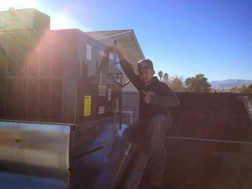 HVAC technician performing Boiler Repair on a rooftop unit in Fairfax
